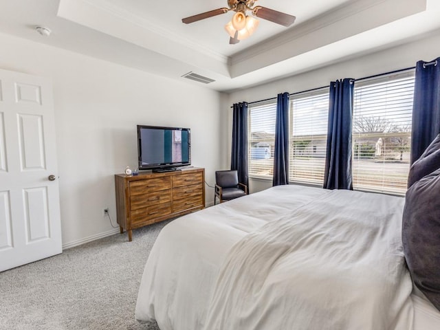 bedroom featuring visible vents, crown molding, baseboards, a tray ceiling, and carpet floors