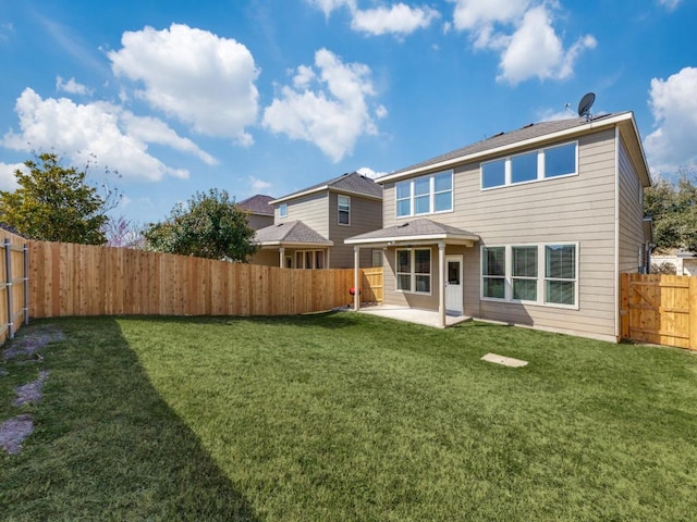 rear view of property featuring a fenced backyard, a lawn, and a patio