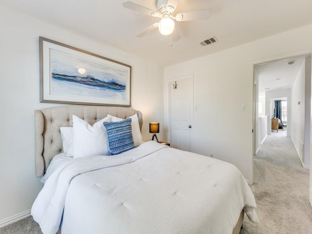 bedroom with visible vents, light colored carpet, a ceiling fan, and baseboards