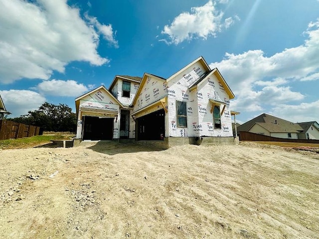 property under construction with a garage and fence