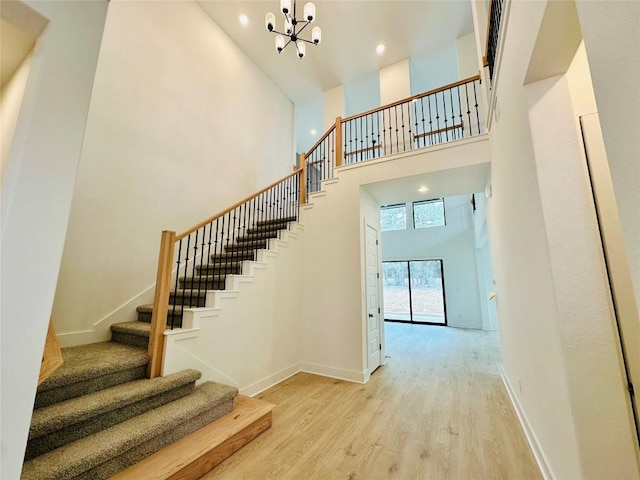 1670 Headwaters Blvd, Dripping Springs, TX 78620 - staircase with a high ceiling, a chandelier, wood finished floors, baseboards, and recessed lighting