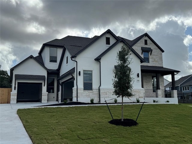 1670 Headwaters Blvd, Dripping Springs, TX 78620 - view of front of home featuring stone siding, a front yard, concrete driveway, and stucco siding