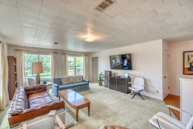 living area featuring baseboards, visible vents, and carpet floors