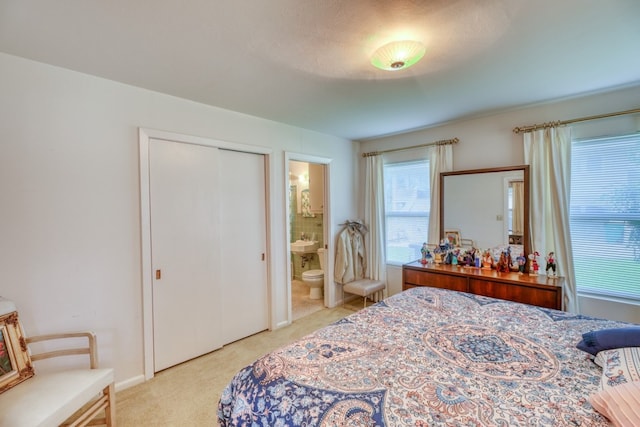 bedroom featuring light colored carpet and ensuite bath