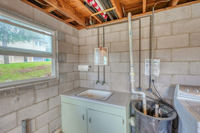 interior space with concrete block wall, washer / clothes dryer, and light countertops