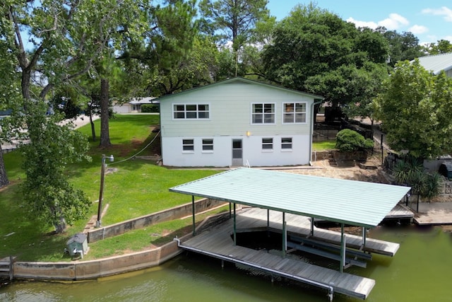 back of house featuring a yard, a water view, and boat lift