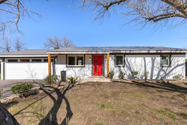 single story home with a garage, driveway, and stucco siding