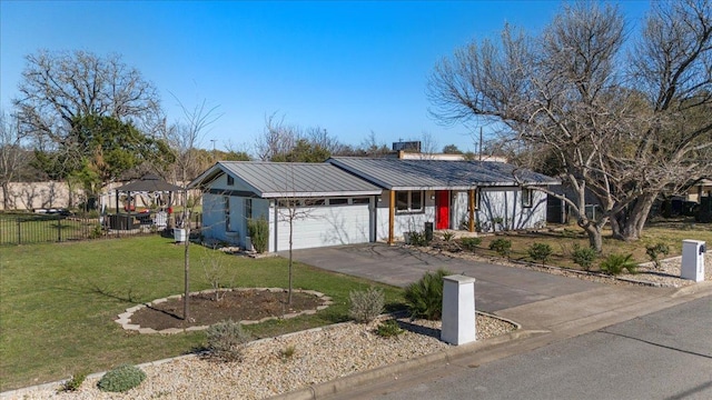 ranch-style home featuring a garage, driveway, fence, a front yard, and metal roof