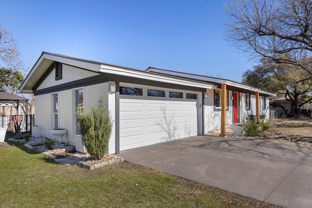 view of front of home with an attached garage, driveway, and stucco siding