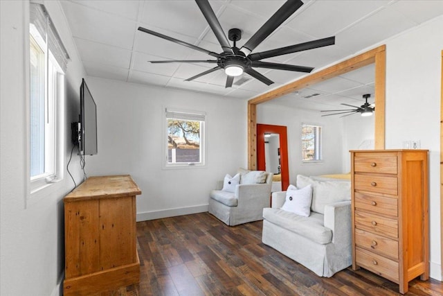 sitting room featuring visible vents, baseboards, dark wood finished floors, a drop ceiling, and a ceiling fan