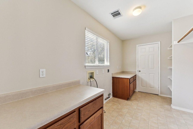 laundry room featuring electric dryer hookup, visible vents, cabinet space, baseboards, and hookup for a washing machine