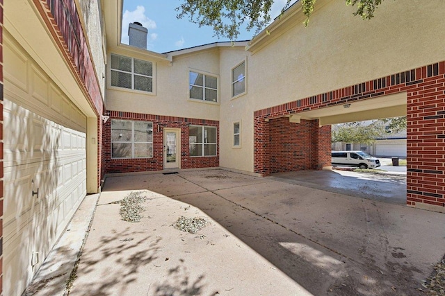 view of patio with driveway and a garage