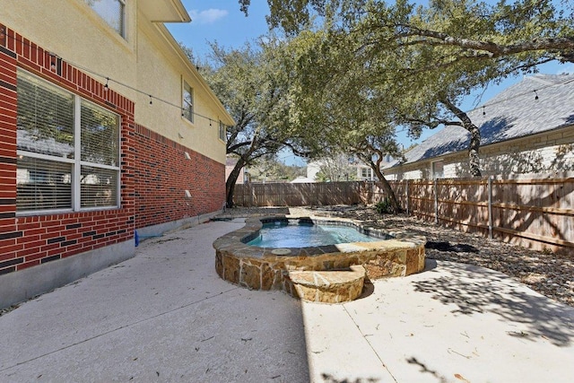 view of pool featuring a patio, an in ground hot tub, and a fenced backyard