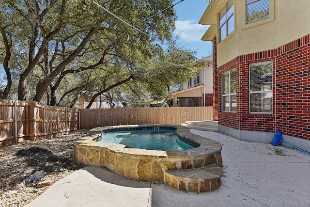 view of pool with an in ground hot tub and a fenced backyard