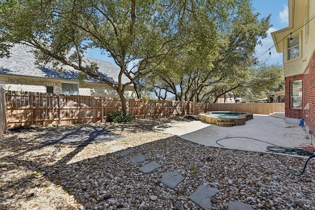 view of yard featuring a fenced backyard, an outdoor hot tub, and a patio area