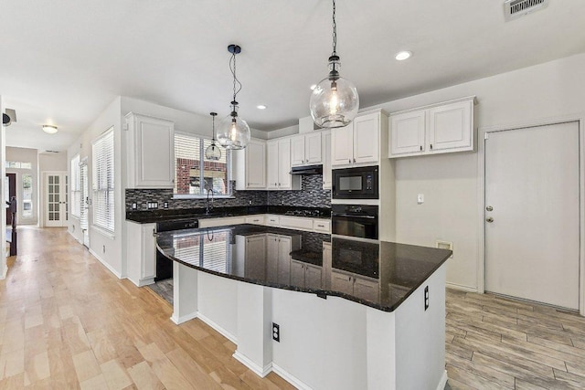 kitchen with visible vents, black appliances, light wood-style flooring, tasteful backsplash, and white cabinetry