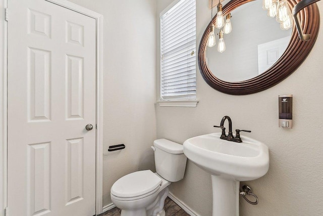 bathroom featuring baseboards and toilet