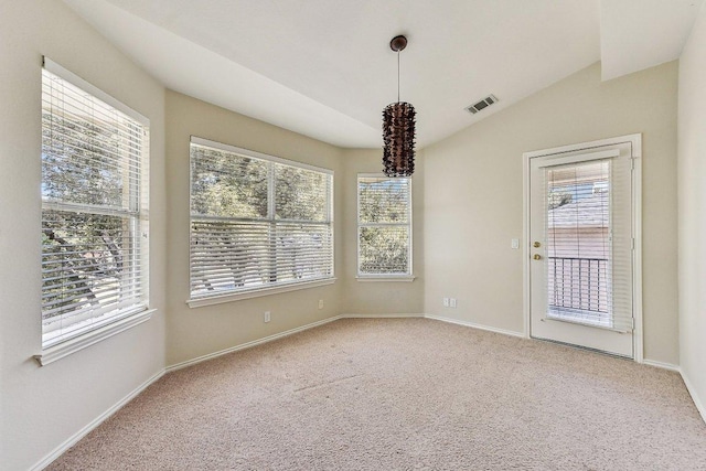 spare room with visible vents, baseboards, carpet, and vaulted ceiling