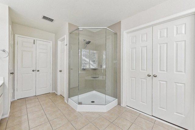 full bath with vanity, tile patterned floors, visible vents, and a stall shower