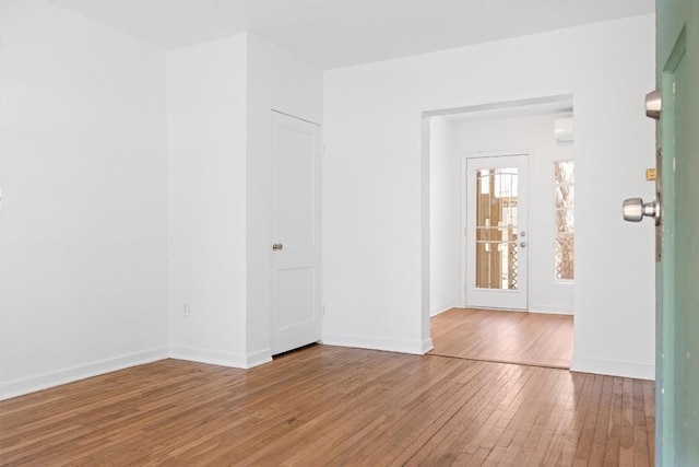 spare room featuring hardwood / wood-style flooring and baseboards