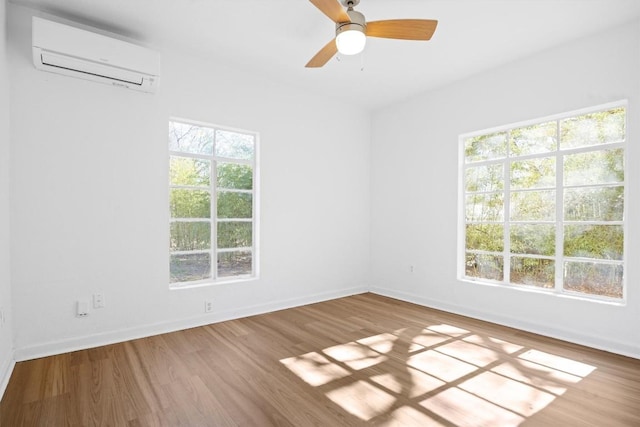 unfurnished room featuring ceiling fan, baseboards, wood finished floors, and a wall unit AC