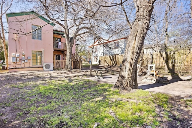 view of yard with stairway, ac unit, a patio area, and a balcony