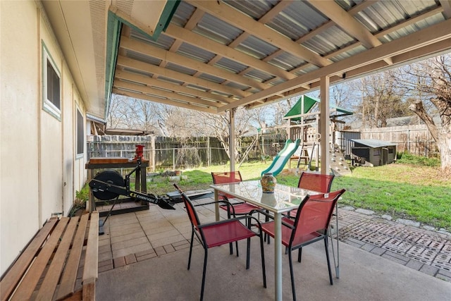 view of patio / terrace with a playground, outdoor dining area, and a fenced backyard