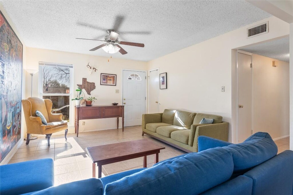 10002 Dorset Dr, Austin, TX 78753 - living area with light tile patterned floors, visible vents, and a textured ceiling