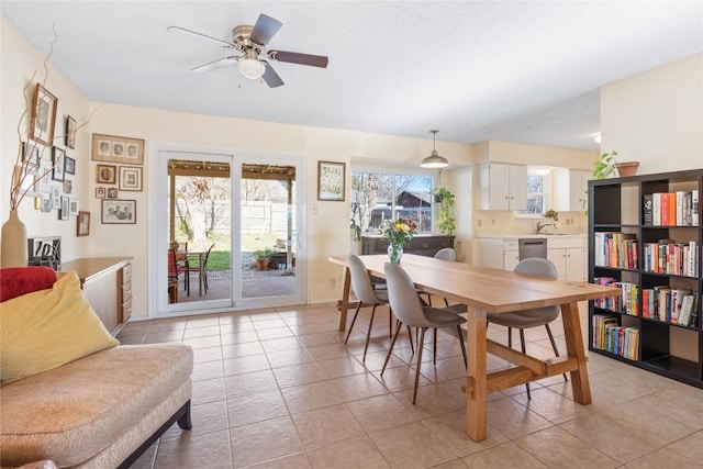 dining space with light tile patterned floors, baseboards, and a ceiling fan