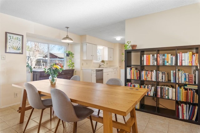 dining room with light tile patterned floors, a textured ceiling, and baseboards