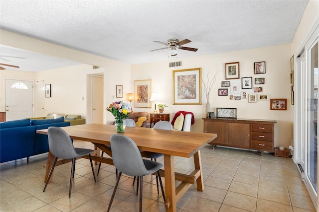 dining room featuring light tile patterned floors, visible vents, a textured ceiling, and ceiling fan