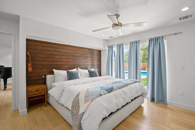 bedroom featuring light wood-style flooring, access to exterior, baseboards, visible vents, and a ceiling fan