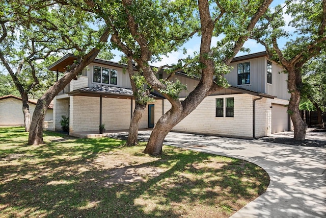 view of front of home featuring brick siding, concrete driveway, and a garage