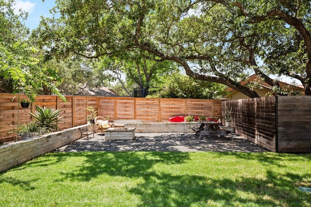 view of yard featuring a fire pit and a fenced backyard