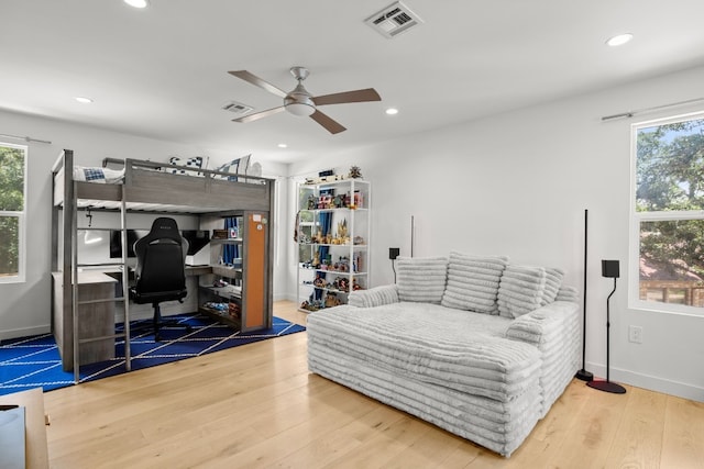 bedroom with visible vents, multiple windows, and wood finished floors