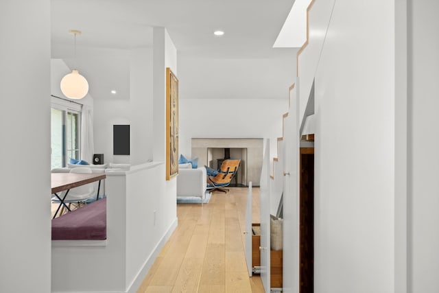 hallway with recessed lighting, light wood finished floors, and baseboards