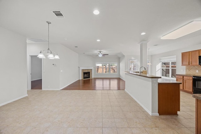 kitchen with recessed lighting, a fireplace, ceiling fan, open floor plan, and tasteful backsplash