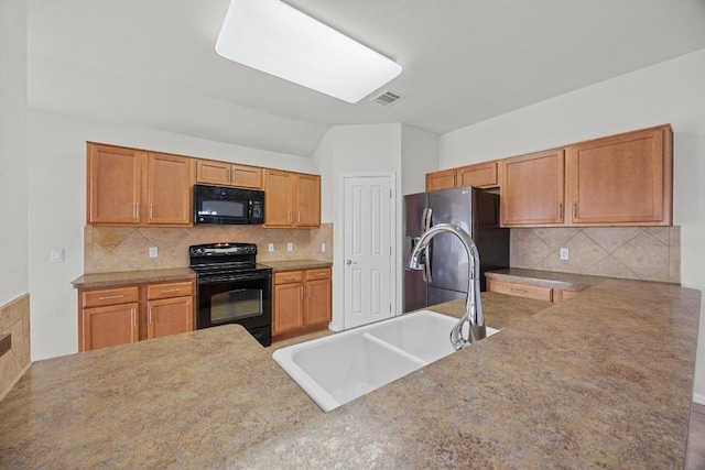 kitchen featuring visible vents, lofted ceiling, a sink, black appliances, and backsplash