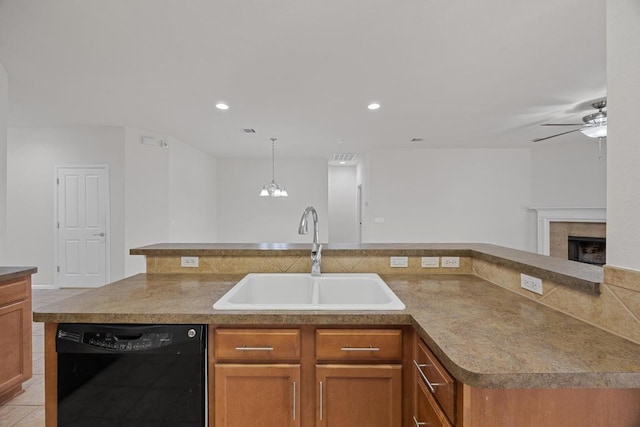 kitchen featuring brown cabinets, a sink, black dishwasher, a fireplace, and ceiling fan