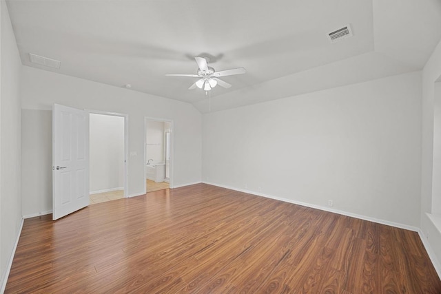 empty room with a ceiling fan, wood finished floors, visible vents, baseboards, and lofted ceiling