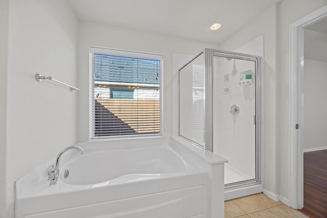 full bathroom with tile patterned floors, baseboards, a bath, and a shower stall