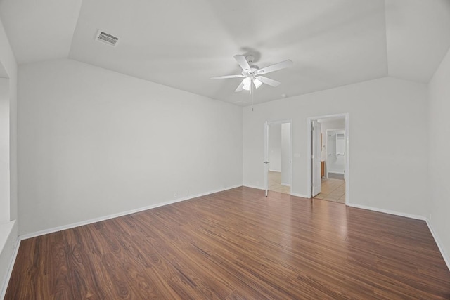 spare room with visible vents, wood finished floors, a ceiling fan, and vaulted ceiling