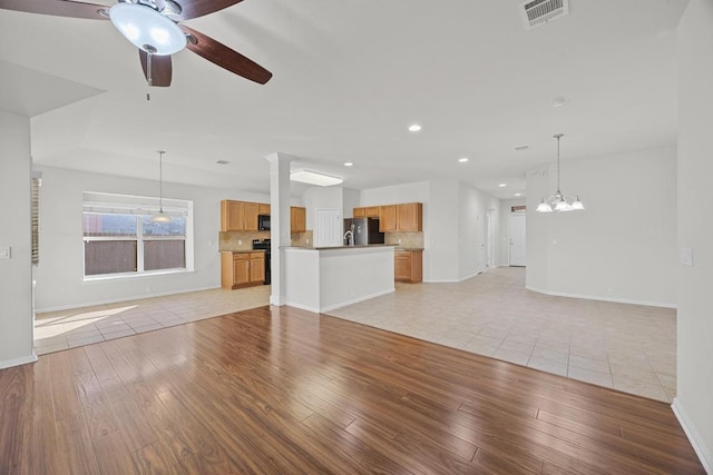 unfurnished living room featuring baseboards, light wood-style floors, visible vents, and ceiling fan