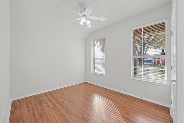 spare room featuring a ceiling fan, lofted ceiling, baseboards, and wood finished floors