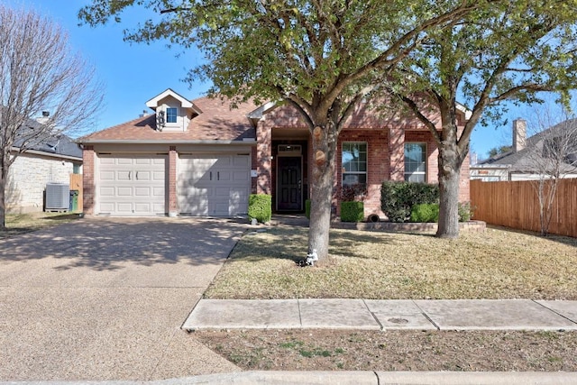 view of front of home with brick siding, fence, cooling unit, a garage, and driveway