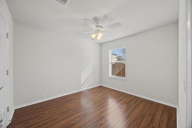 spare room featuring baseboards, dark wood-type flooring, and ceiling fan