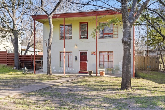 view of front facade with stucco siding and fence