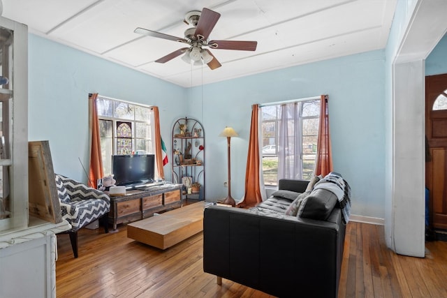 living area with wood-type flooring, a healthy amount of sunlight, and ceiling fan