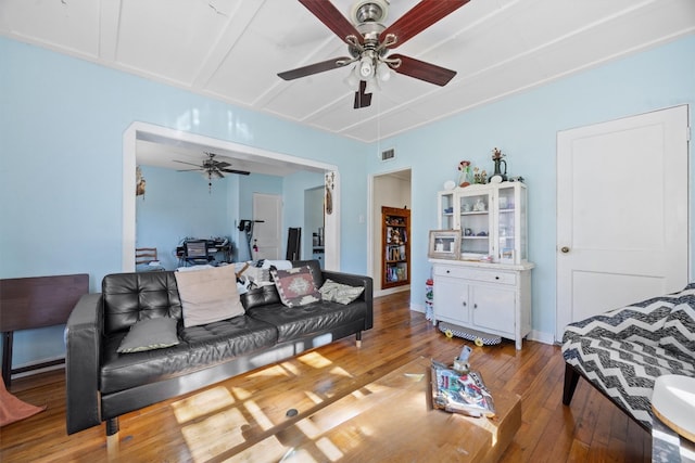 living area featuring visible vents, baseboards, a ceiling fan, and hardwood / wood-style flooring