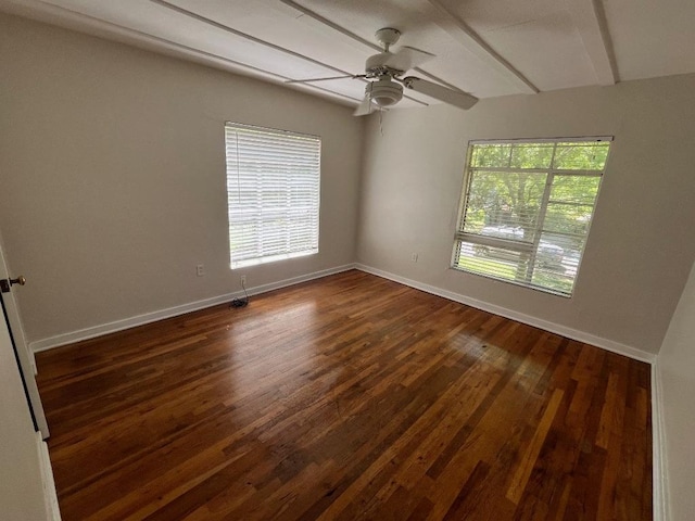 empty room featuring baseboards, dark wood-style flooring, and ceiling fan